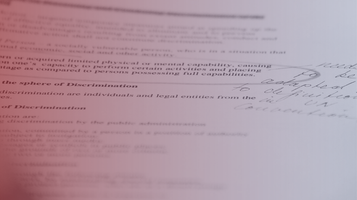 Legal document with handwritten notes, viewed at an angle, in soft red lighting.