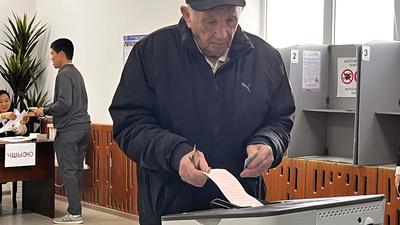 Elderly man voting at a machine during early parliamentary elections Bishkek, 30 November 2025