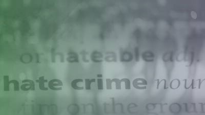 Blurred text with the words "hate crime" in focus, green and gray hues.
