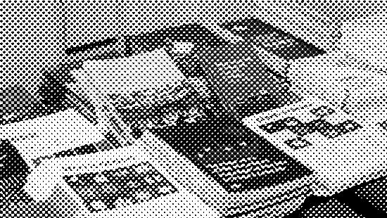 Stacks of colorful booklets and brochures on a table, arranged neatly in piles.